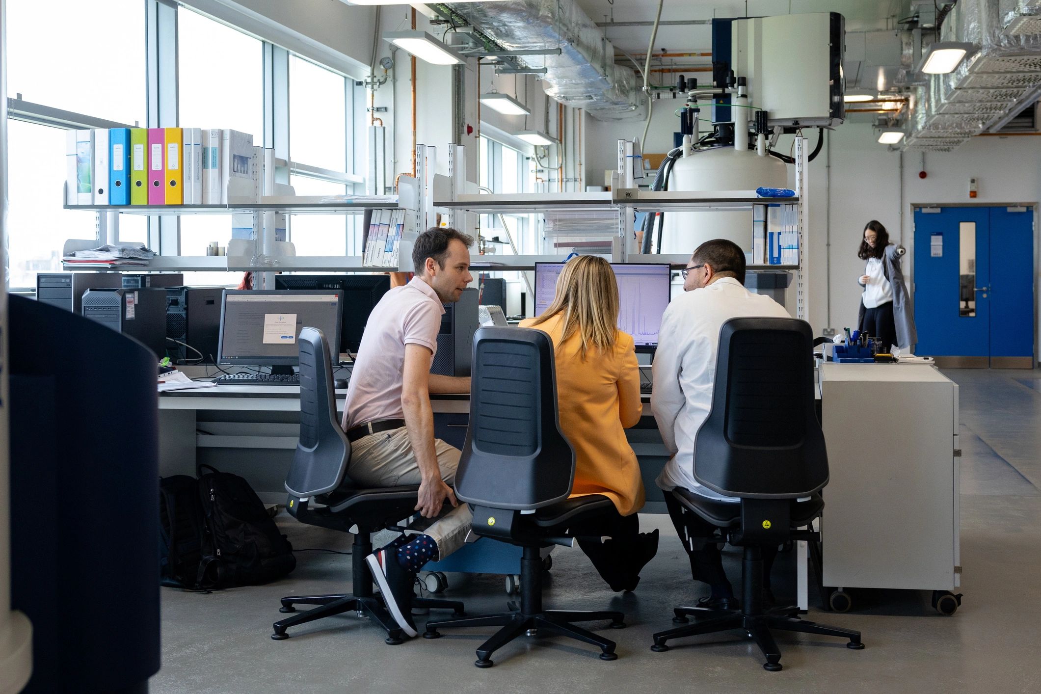 Biotech professionals collaborating around a computer
