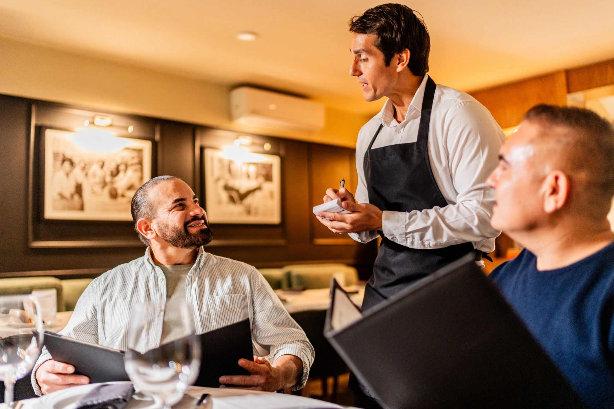 Waiter serving restaurant guests during dinner